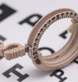 An eye exam chart displayed alongside a pair of glasses, illustrating vision testing equipment and tools.