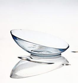A close-up view of a pair of contact lenses on a white surface, emphasizing their delicate and transparent appearance.